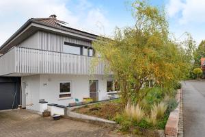 a white house with a tree in front of it at Apartment Dreiländer Blick in Wintersweiler