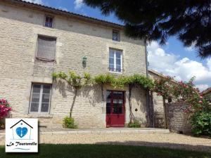 a large stone house with a red door at Domaine De Chante-Oiseau - 28 pers in Theil-Rabier