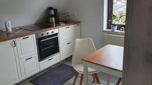 a kitchen with white cabinets and a table and a stove at Fewo Drei Gleichen Nr 1 in Wandersleben