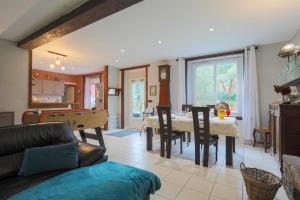 a living room with a couch and a dining room with a pool table at L'Annexe du Petit Echo de la mode in Plélo