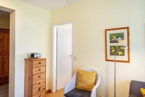 a living room with a chair and a dresser at Möve Aba Appartment 11 in Rerik