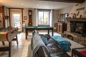 a living room with a couch and a pool table at L'Annexe du Petit Echo de la mode in Plélo