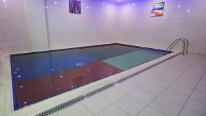 a pool in a gymnasium with ailed floor at Jowharet AlMaseya in Al Khobar
