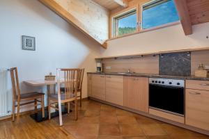 a kitchen with a table and a stove at Funtnatsch Apartment Langkofel in Laion