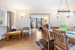 a dining room and living room with a table and chairs at De Lüüte Kaat in Offenbüttel +16 photos
