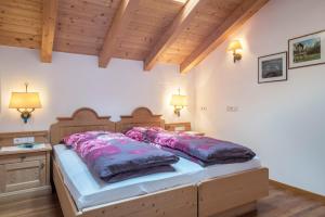 a large bed in a room with wooden ceilings at Funtnatsch Apartment Langkofel in Laion