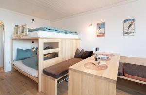 a small room with a bunk bed and a desk at Mountain View Corones in Reischach