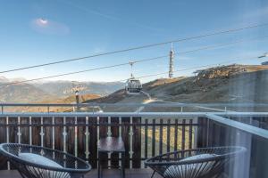 a balcony with a view of a train on a mountain at Mountain View Corones in Reischach