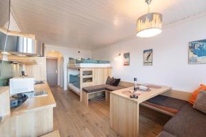 a living room with a desk and a room with bunk beds at Mountain View Corones in Reischach