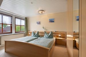 a bedroom with a large bed with blue pillows at Haus Hachmann Wesselburen in Wesselburen