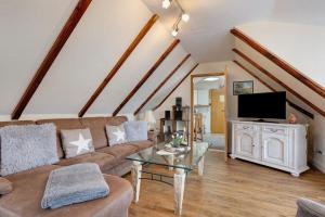 a living room with a couch and a tv at Haus Hachmann Wesselburen in Wesselburen
