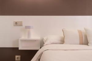 a bedroom with a white bed and a night stand at Santa Teresuca en Santander in Santander