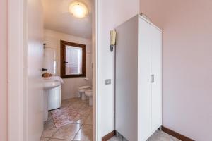 a white bathroom with a toilet and a sink at Tara house in Pula +17 photos