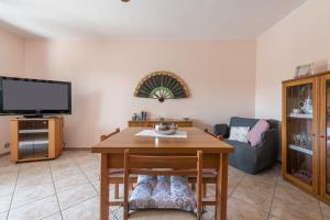 a living room with a table and a tv at Tara house in Pula