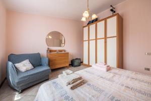 a bedroom with a large bed and a chair at Tara house in Pula