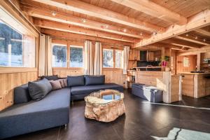 a living room with a blue couch and a table at Chalet Le Mas Devant in Morillon