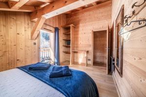 a bedroom with a bed in a wooden cabin at Chalet Le Mas Devant in Morillon