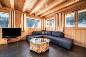 a living room with a couch and a tv at Chalet Le Mas Devant in Morillon