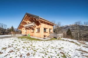 a wooden house on a hill in the snow at Chalet Le Mas Devant in Morillon