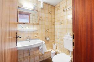 a bathroom with a sink and a toilet at Hotel Bären - drei Sterne in Bernau im Schwarzwald +150 photos