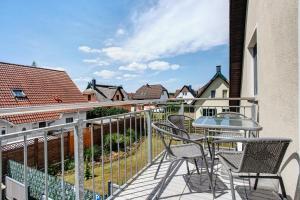 a balcony with a table and chairs and buildings at Abendsonne in Koserow