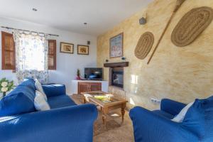 a living room with blue couches and a fireplace at Fuente luz cottage in Frigiliana