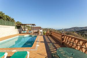 a villa with a swimming pool on a hill at Fuente luz cottage in Frigiliana