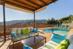a patio with a couch and chairs next to a pool at Fuente luz cottage in Frigiliana