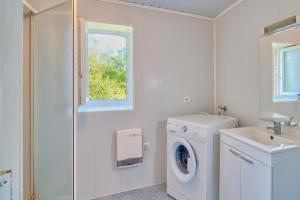 a white laundry room with a washing machine and a window at Quiétude in Meyrals