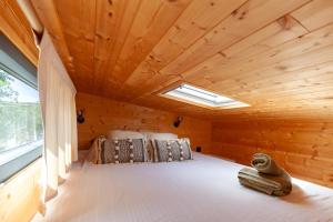 a bedroom in a log cabin with a skylight at Bali House in Peypin