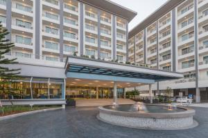 a large building with a fountain in front of it at Kantary Hotel And Serviced Apartment, Amata, Bangpakong in Ban Tamru