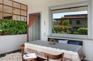 a table and chairs on a porch with a window at Casa vacanze al Boschetto in Masina