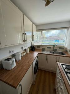 a kitchen with white cabinets and a wooden counter top at fir tree in Southampton