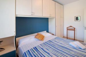 a bedroom with a bed with a blue headboard and white cabinets at Casa vacanze al Boschetto in Masina