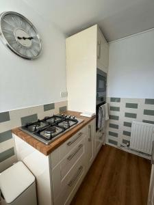 a kitchen with a stove and a clock on the wall at fir tree in Southampton