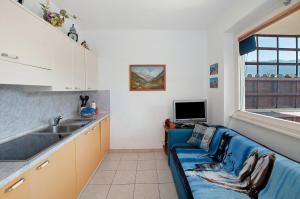 a living room with a blue couch in a kitchen at Casa vacanze al Boschetto in Masina