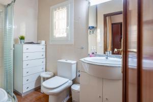 a white bathroom with a sink and a toilet at Maison La Coquette L' Escala in L'Escala +18 photos
