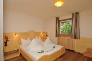 a bedroom with a bed with white sheets and a window at Residence Nussbaumer in Siusi +65 photos