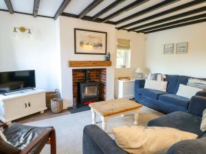 a living room with a blue couch and a fireplace at Craig Mawr in Benllech