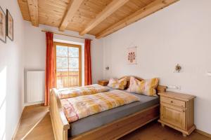 a bedroom with a bed and a window at Heinzenhof Welschnofen in Nova Levante