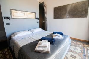 a hotel room with a bed with towels on it at C-Home Historic House in Otranto