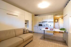 a living room with a couch and a table and a kitchen at Modern Practical Studio In Sauze in Sauze d'Oulx