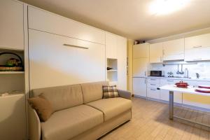 a living room with a couch and a kitchen at Modern Practical Studio In Sauze in Sauze d'Oulx +27 photos