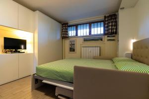a small bedroom with a bed and a television at Modern Practical Studio In Sauze in Sauze d'Oulx