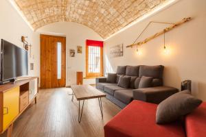 a living room with a couch and a tv at Sant Rafel House in Arenys de Mar