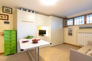 a living room with a table and a green dresser at Modern Practical Studio In Sauze in Sauze d'Oulx