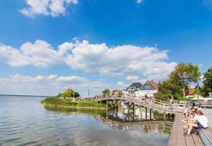 people sitting on a dock next to a body of water at Studio in Steinhude