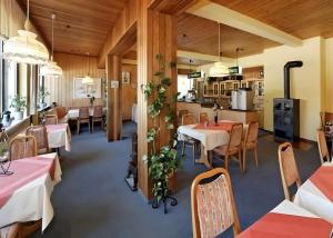 a restaurant with tables and chairs and a kitchen at Hotel Schachten in Lindberg