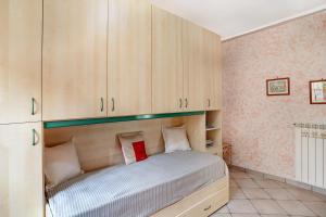 a bedroom with a bed with wooden cabinets at Casa di Lo in Laigueglia