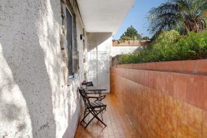 a patio with two chairs and a table on a wall at Casa di Lo in Laigueglia